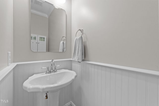 7908 Mayapple Pl, Raleigh, NC 27613 - bathroom featuring a wainscoted wall, ornamental molding, and a decorative wall