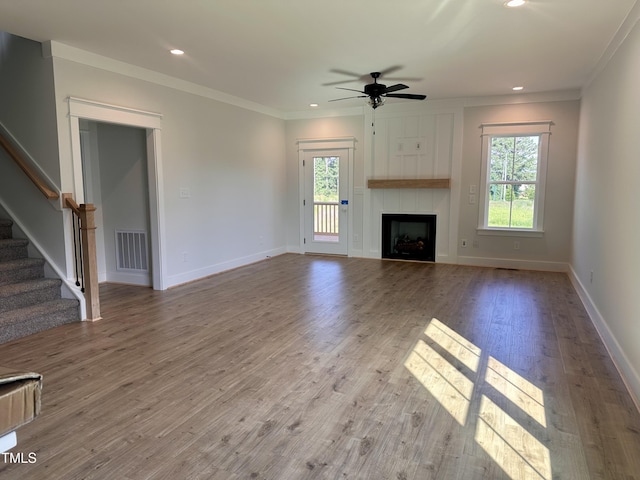 163 Noramac Ct, Selma, NC 27576 - unfurnished living room with plenty of natural light, a ceiling fan, stairs, a large fireplace, and ornamental molding