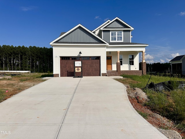 163 Noramac Ct, Selma, NC 27576 - view of front facade with driveway, covered porch, board and batten siding, and a garage