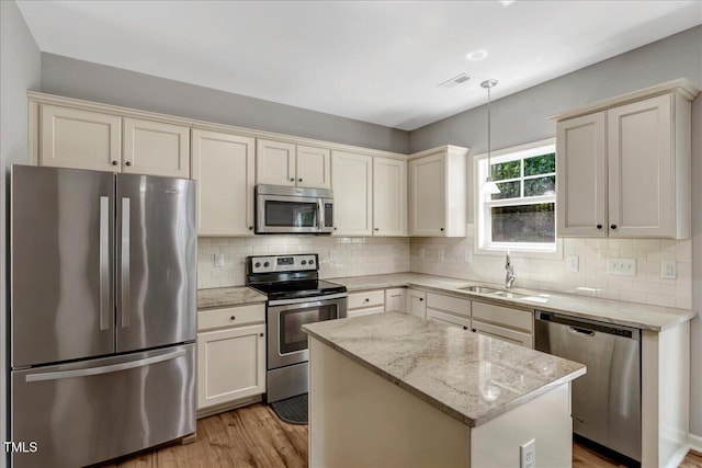 205 Willow Ridge Dr, Louisburg, NC 27549 - kitchen featuring stainless steel appliances, light wood-type flooring, backsplash, and a center island