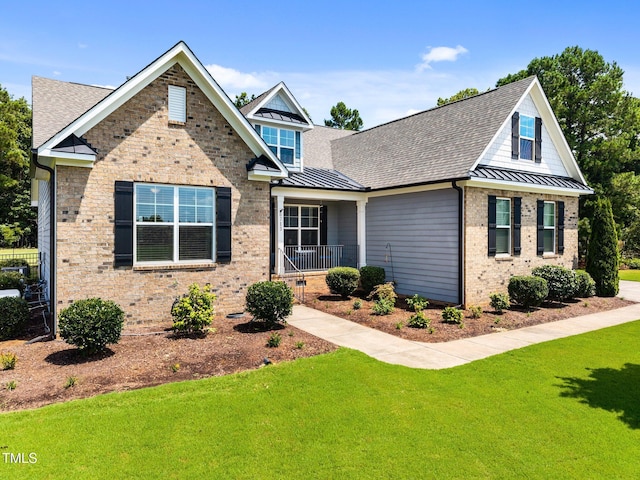 8713 Halsey Ln, Wake Forest, NC 27587 - view of front of home with a standing seam roof, brick siding, a front yard, and roof with shingles