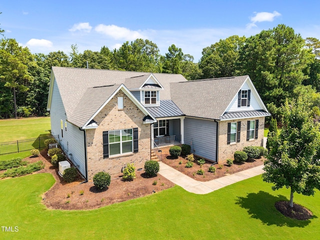 8713 Halsey Ln, Wake Forest, NC 27587 - view of front of house featuring brick siding, a standing seam roof, a metal roof, covered porch, and view of wooded area