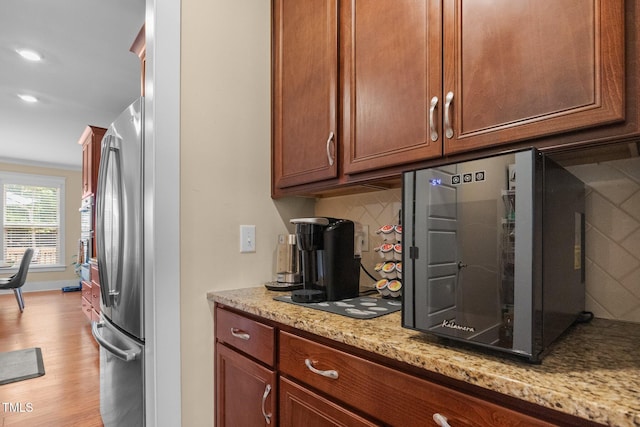 8713 Halsey Ln, Wake Forest, NC 27587 - kitchen with freestanding refrigerator, light wood-style flooring, decorative backsplash, light stone counters, and recessed lighting