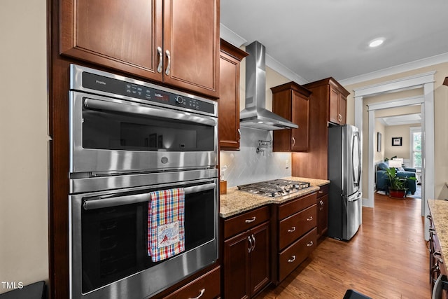 8713 Halsey Ln, Wake Forest, NC 27587 - kitchen with wall chimney range hood, appliances with stainless steel finishes, ornamental molding, wood finished floors, and light stone countertops