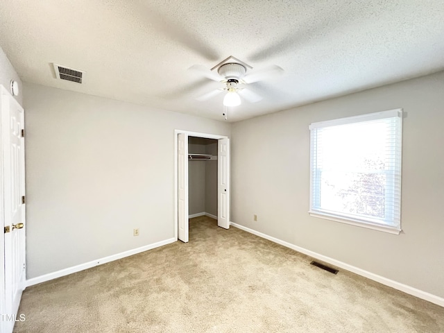 2206 Alpine Rd, Durham, NC 27707 - unfurnished bedroom with carpet flooring, a closet, a ceiling fan, and a textured ceiling
