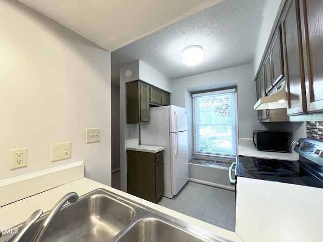 2206 Alpine Rd, Durham, NC 27707 - kitchen with range with electric cooktop, light tile patterned floors, dark brown cabinetry, a textured ceiling, and freestanding refrigerator