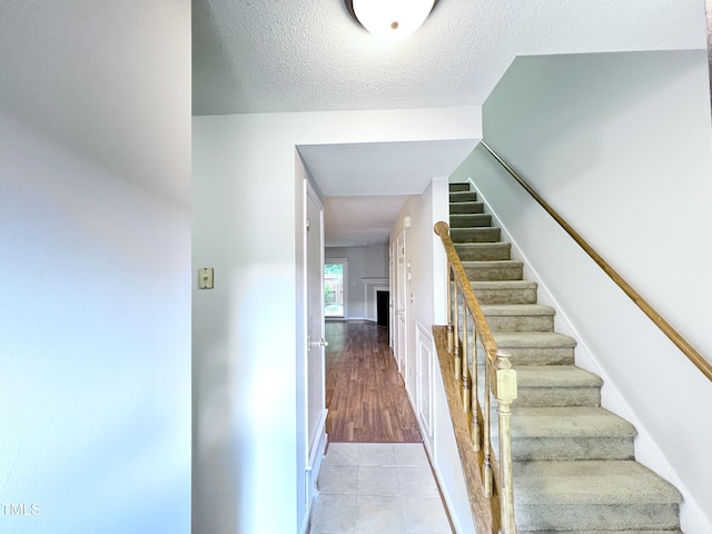 2206 Alpine Rd, Durham, NC 27707 - stairs with a textured ceiling and tile patterned flooring
