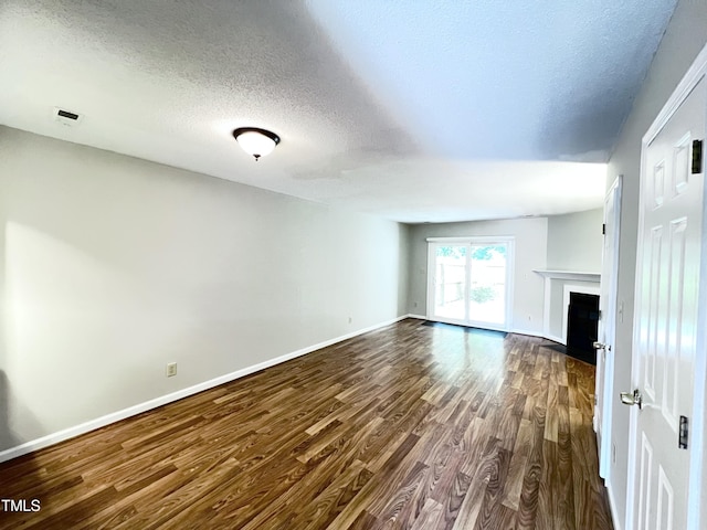 2206 Alpine Rd, Durham, NC 27707 - unfurnished living room with dark wood-type flooring, a textured ceiling, and a fireplace