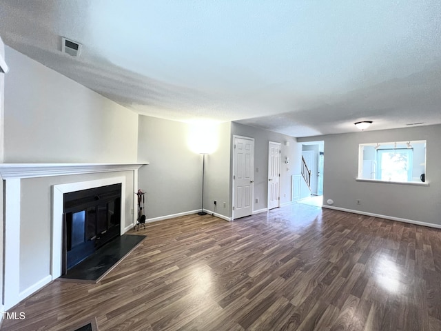 2206 Alpine Rd, Durham, NC 27707 - unfurnished living room featuring wood finished floors, a glass covered fireplace, and a textured ceiling