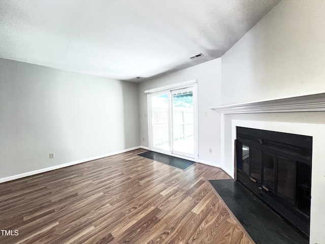 2206 Alpine Rd, Durham, NC 27707 - unfurnished living room featuring a fireplace with flush hearth, dark wood-type flooring, and a textured ceiling
