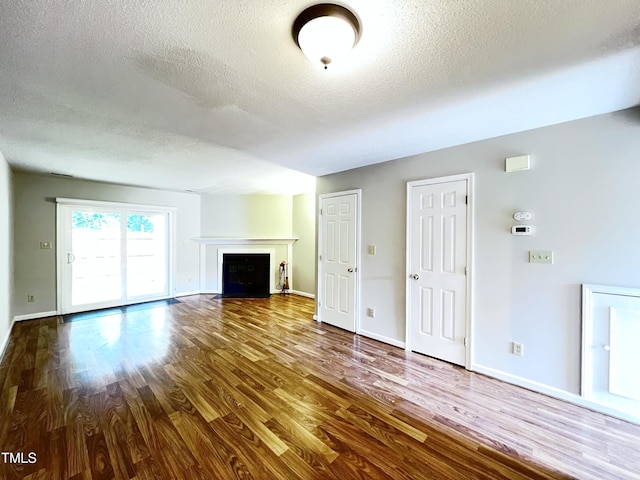 2206 Alpine Rd, Durham, NC 27707 - unfurnished living room featuring a textured ceiling, wood finished floors, and a fireplace with flush hearth