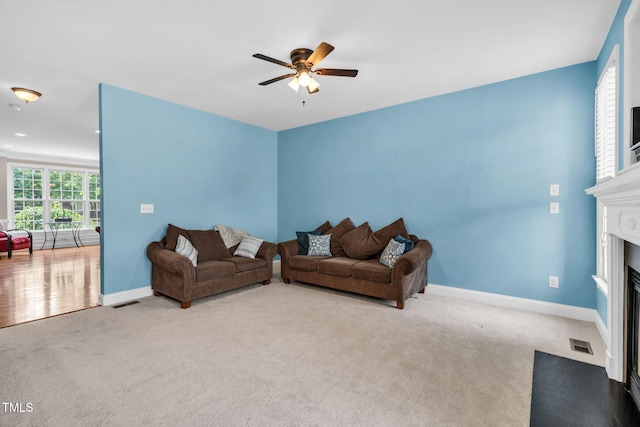 2506 Happy Ln, Raleigh, NC 27614 - living room featuring a fireplace with flush hearth, carpet floors, and ceiling fan