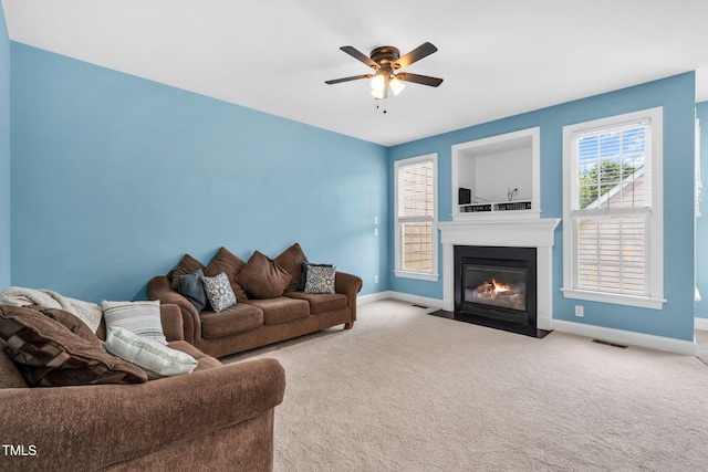 2506 Happy Ln, Raleigh, NC 27614 - carpeted living room with ceiling fan and a fireplace with flush hearth