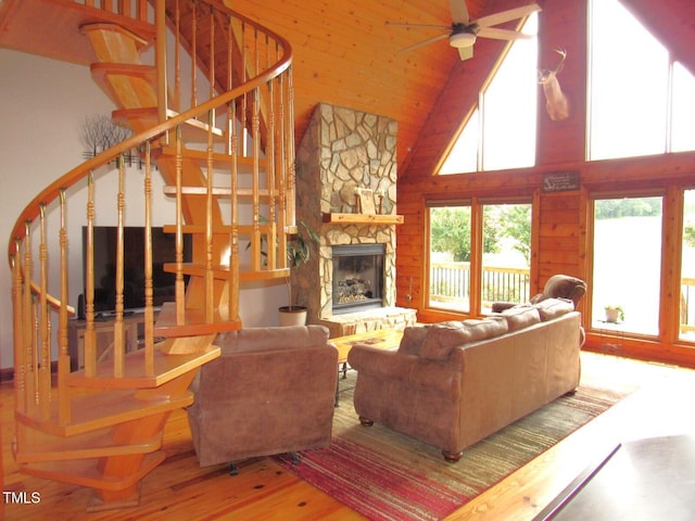 1159 Flemingtown Rd, Henderson, NC 27537 - living area with wood finished floors, high vaulted ceiling, stairs, a ceiling fan, and a fireplace