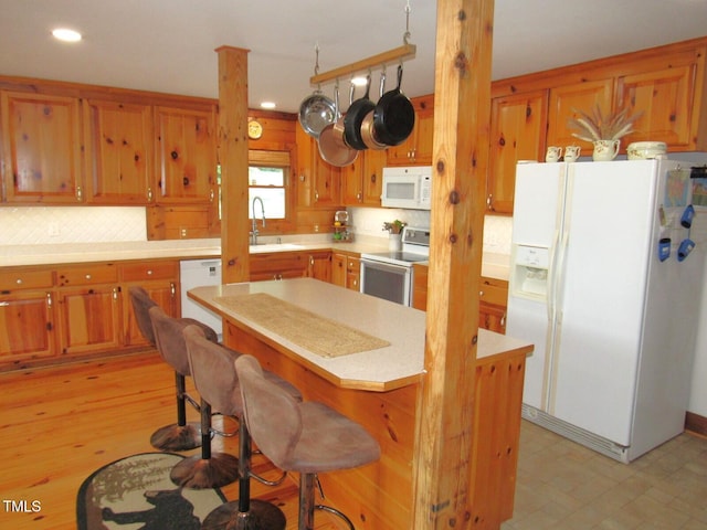 1159 Flemingtown Rd, Henderson, NC 27537 - kitchen with white appliances, light countertops, tasteful backsplash, brown cabinets, and recessed lighting