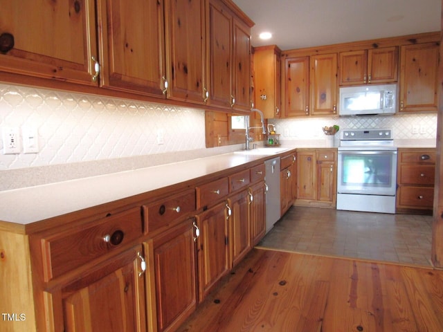 1159 Flemingtown Rd, Henderson, NC 27537 - kitchen featuring white appliances, brown cabinetry, light countertops, and recessed lighting