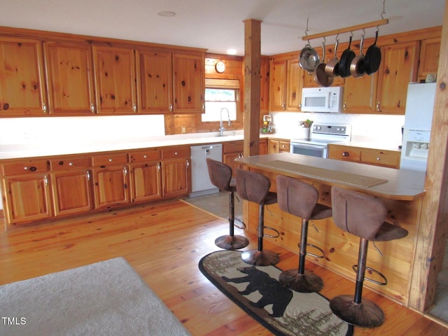 1159 Flemingtown Rd, Henderson, NC 27537 - kitchen featuring white appliances, brown cabinets, and light wood-style floors