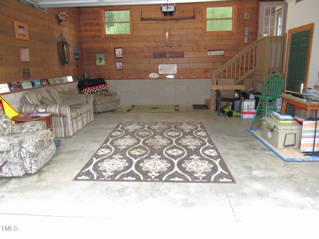 1159 Flemingtown Rd, Henderson, NC 27537 - living area featuring wooden walls, unfinished concrete floors, and stairs