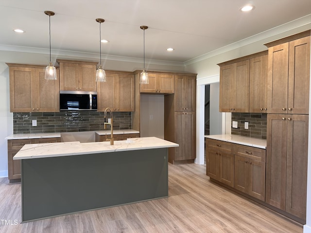 141 Noramac Ct, Selma, NC 27576 - kitchen featuring stainless steel microwave, crown molding, backsplash, hanging light fixtures, and light wood-type flooring