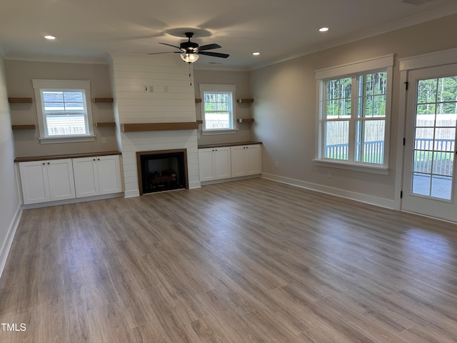 141 Noramac Ct, Selma, NC 27576 - unfurnished living room featuring crown molding, a ceiling fan, light wood finished floors, a large fireplace, and recessed lighting
