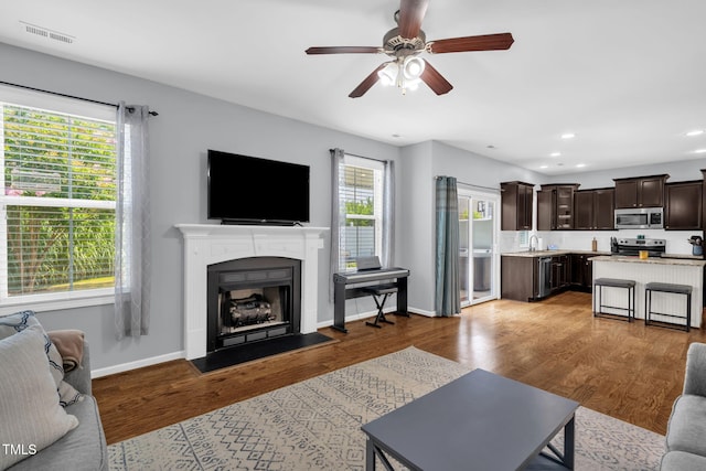 3716 Landshire View Ln, Raleigh, NC 27616 - living area featuring a fireplace with flush hearth, a ceiling fan, recessed lighting, and wood finished floors