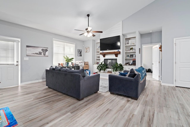 9448 S Beaver Creek Way, Middlesex, NC 27557 - living room featuring ceiling fan, light wood finished floors, built in shelves, vaulted ceiling, and a large fireplace