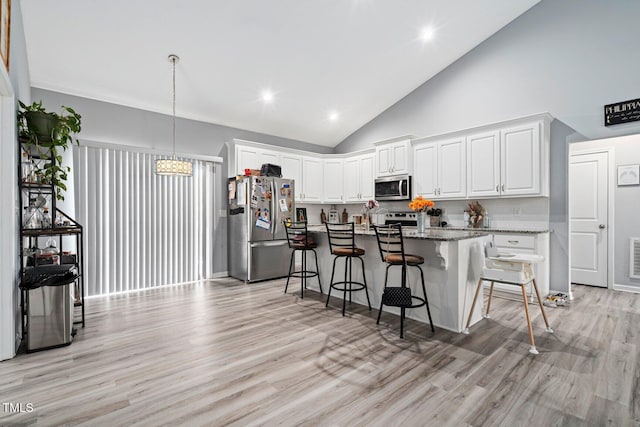 9448 S Beaver Creek Way, Middlesex, NC 27557 - kitchen featuring appliances with stainless steel finishes, a kitchen bar, white cabinetry, light wood-style flooring, and high vaulted ceiling