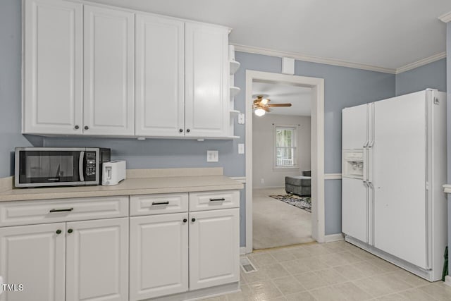 216 S Faison Ave, Faison, NC 28341 - kitchen featuring white fridge with ice dispenser, stainless steel microwave, ceiling fan, white cabinets, and crown molding
