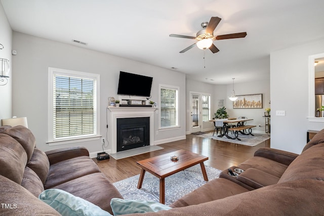 701 Laurel Spring Dr, Fuquay Varina, NC 27526 - living room featuring plenty of natural light, ceiling fan, wood finished floors, and a glass covered fireplace