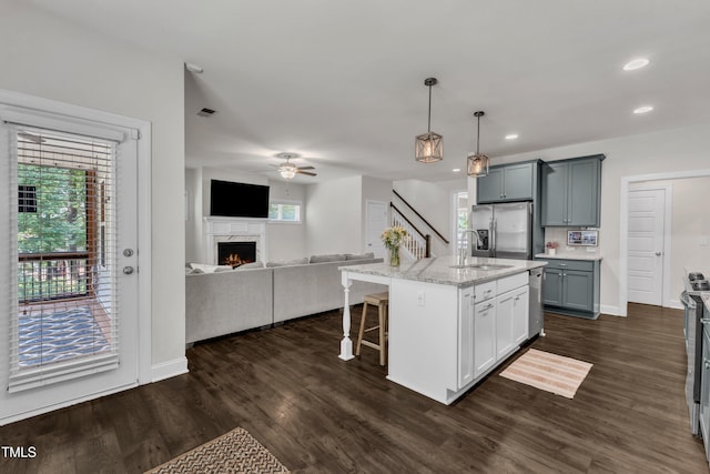 1725 River Club Way, Franklinton, NC 27525 - kitchen with appliances with stainless steel finishes, a breakfast bar, open floor plan, a fireplace, and ceiling fan