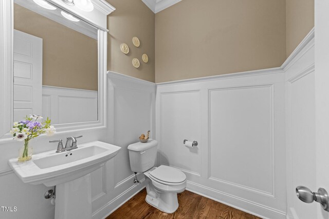 5005 Clyden Cv, Raleigh, NC 27612 - half bath with a decorative wall, a wainscoted wall, wood finished floors, and crown molding