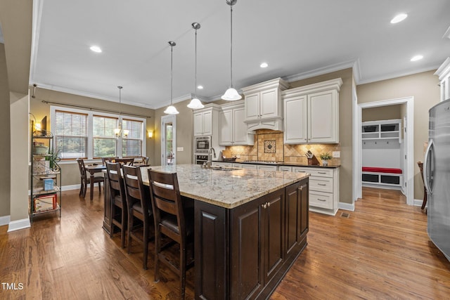 5005 Clyden Cv, Raleigh, NC 27612 - kitchen with freestanding refrigerator, crown molding, decorative backsplash, dark wood finished floors, and white cabinets