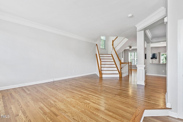 306 Kirkeenan Cir, Morrisville, NC 27560 - unfurnished living room featuring stairway, light wood-style flooring, crown molding, and ornate columns