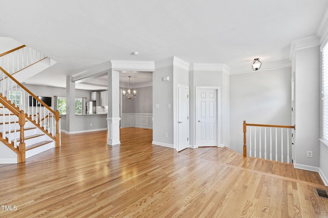 306 Kirkeenan Cir, Morrisville, NC 27560 - unfurnished living room with light wood-style floors, a chandelier, ornamental molding, and stairway