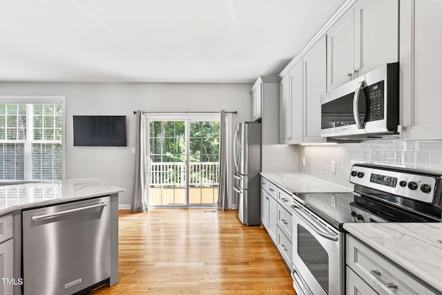306 Kirkeenan Cir, Morrisville, NC 27560 - kitchen with appliances with stainless steel finishes, plenty of natural light, light wood-type flooring, and decorative backsplash