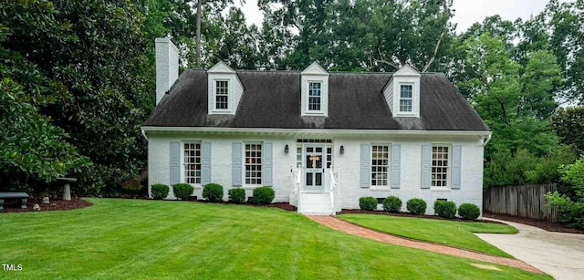 809 Blenheim Dr, Raleigh, NC 27612 - cape cod home with a chimney, stucco siding, and view of wooded area