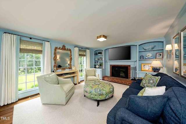 809 Blenheim Dr, Raleigh, NC 27612 - living room featuring a fireplace, wood finished floors, ornamental molding, and built in features