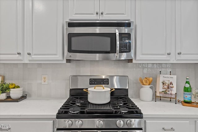 49 Brookridge Ct, Pittsboro, NC 27312 - kitchen with appliances with stainless steel finishes, white cabinetry, tasteful backsplash, and light stone countertops