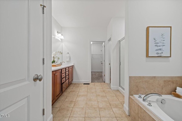 49 Brookridge Ct, Pittsboro, NC 27312 - bathroom featuring vanity, a garden tub, a stall shower, tile patterned flooring, and a walk in closet