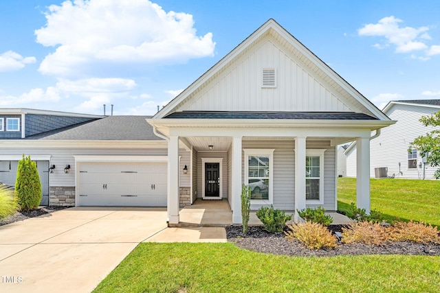 6531 Knob Creek Dr, Whitsett, NC 27377 - view of front facade with board and batten siding, covered porch, a garage, concrete driveway, and a front yard