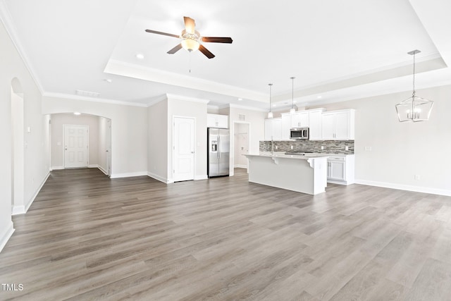 6531 Knob Creek Dr, Whitsett, NC 27377 - unfurnished living room with a raised ceiling, ceiling fan, light wood-style flooring, recessed lighting, and ornamental molding