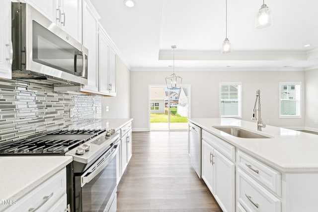 6531 Knob Creek Dr, Whitsett, NC 27377 - kitchen featuring stainless steel appliances, crown molding, backsplash, light wood-type flooring, and hanging light fixtures