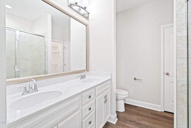 6531 Knob Creek Dr, Whitsett, NC 27377 - bathroom featuring double vanity, wood finished floors, a shower with door, and a spacious closet
