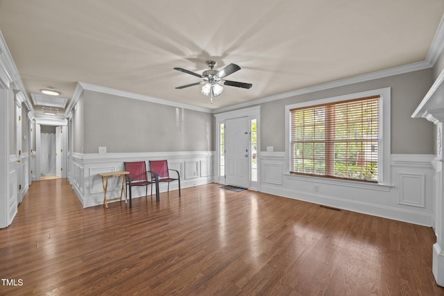 305 Justice Heights St, Apex, NC 27502 - foyer featuring healthy amount of natural light, a ceiling fan, wood finished floors, a wainscoted wall, and crown molding