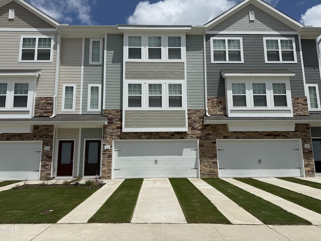 5332 River Reach Dr, Raleigh, NC 27616 - townhome / multi-family property with stone siding, a garage, and concrete driveway
