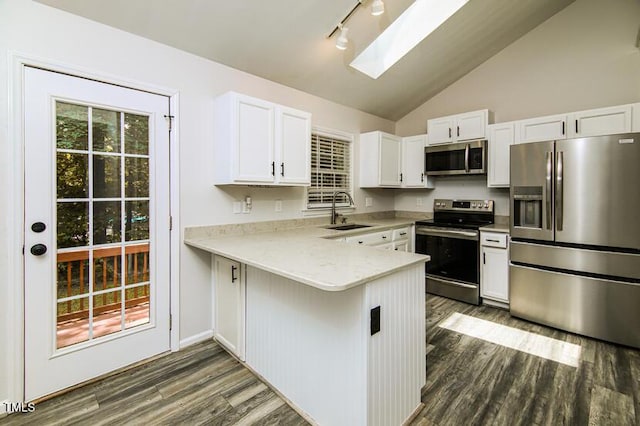 190 Hardwood Dr, Franklinton, NC 27525 - kitchen with appliances with stainless steel finishes, dark wood finished floors, white cabinets, a peninsula, and a skylight