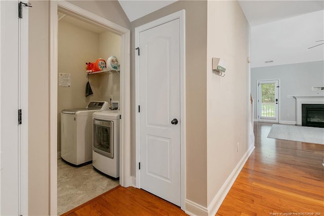 1234 Micahs Way N, Spring Lake, NC 28390 - washroom featuring wood finished floors, washing machine and clothes dryer, and a fireplace with flush hearth