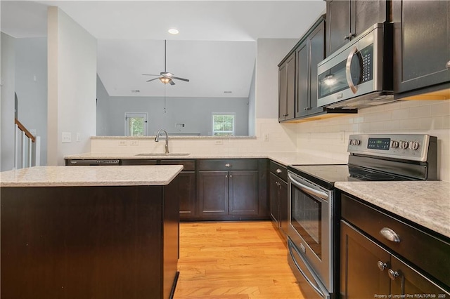 1234 Micahs Way N, Spring Lake, NC 28390 - kitchen featuring appliances with stainless steel finishes, a ceiling fan, light wood-type flooring, backsplash, and a peninsula
