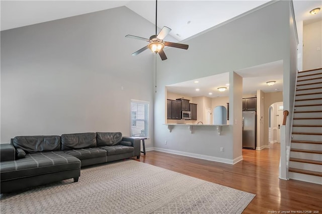 1234 Micahs Way N, Spring Lake, NC 28390 - living room featuring ceiling fan, wood finished floors, stairway, arched walkways, and high vaulted ceiling