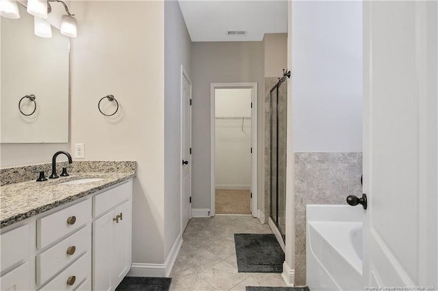1234 Micahs Way N, Spring Lake, NC 28390 - bathroom featuring a shower stall, vanity, a bath, and a spacious closet